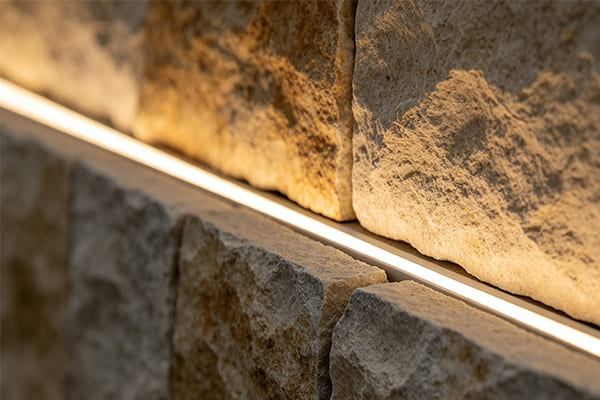 Close-up of a concealed linear light embedded in a stone wall joint